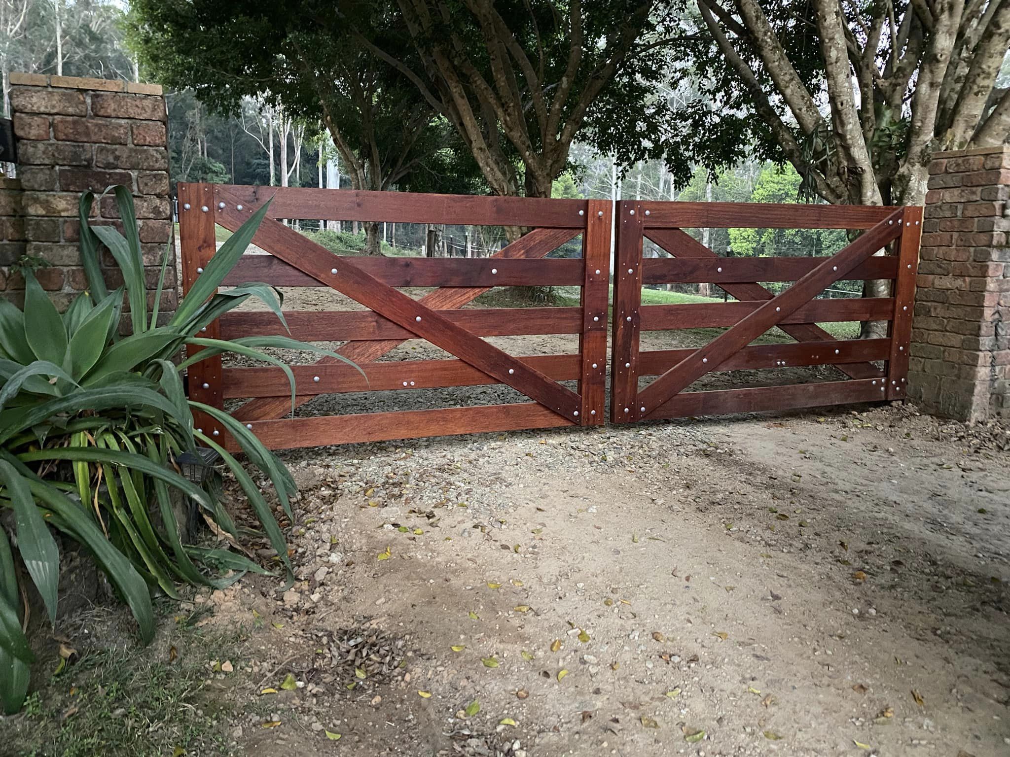 Double hardwood cross brace gates with solar powered remote automatic gate opener.